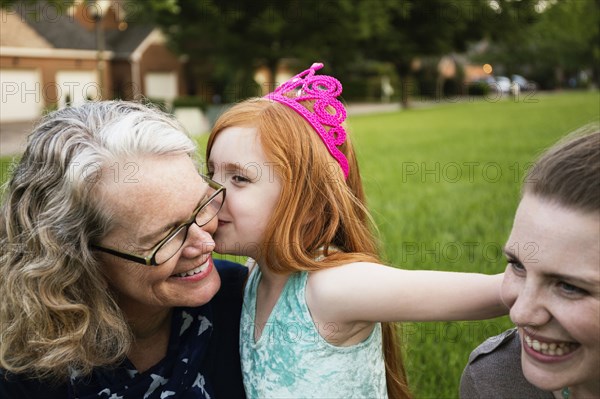 Three generations of Caucasian women sitting in park