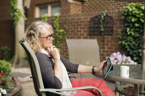 Caucasian woman using tablet computer outdoors