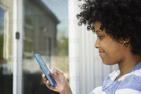 Mixed race woman using cell phone outdoors