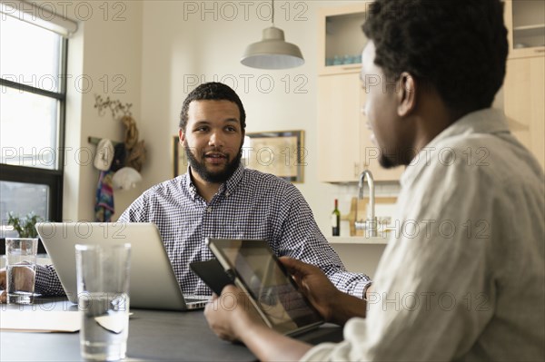 Friends using technology at breakfast table