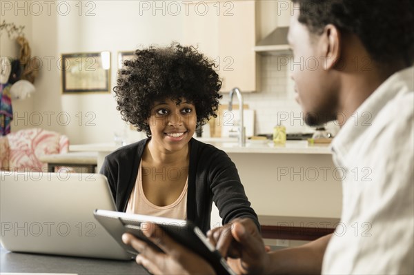 Couple using technology at breakfast table