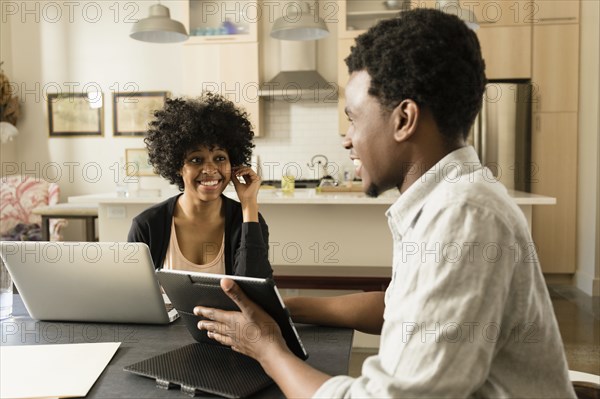 Couple using technology at breakfast table