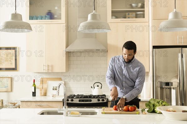 Mixed race man cooking in kitchen