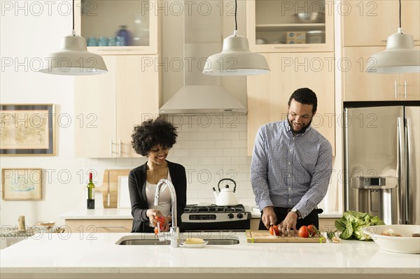 Mixed race couple cooking together in kitchen