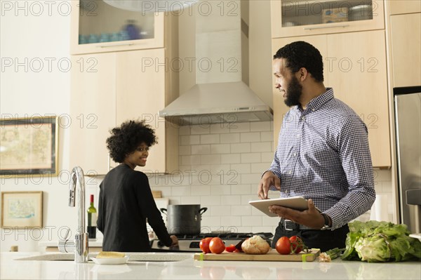 Mixed race couple cooking together in kitchen