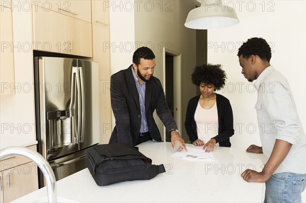 Couple talking to broker in new house