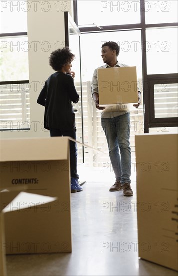 Couple hauling cardboard boxes to new house