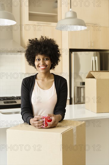 Mixed race woman drinking coffee in new house