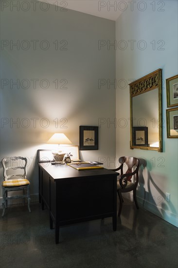 Illuminated lamp on desk in study