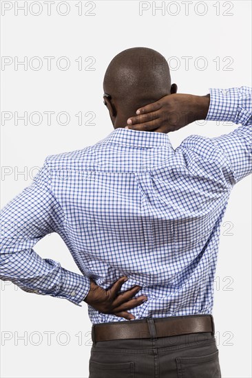 Black man rubbing aching back and neck