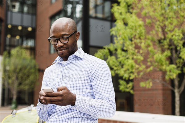 Black man using cell phone in city