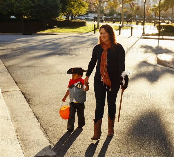 Mother and son dressed as cowboy crossing street