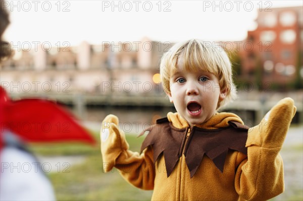 Caucasian boy playing in lion costume outdoors