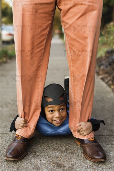 African American boy trick-or-treating with father on Halloween