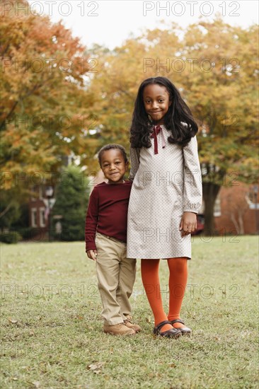 African American brother and sister smiling in park