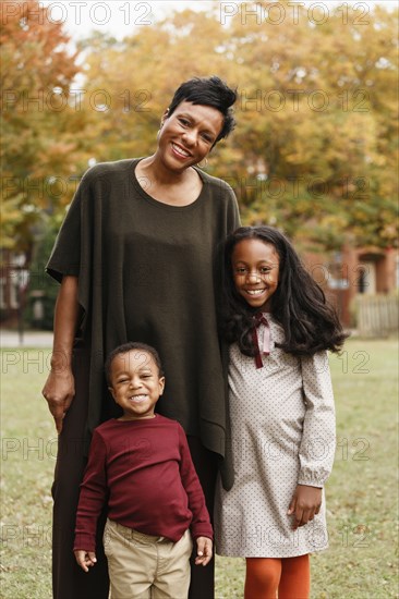 African American mother and children smiling in park