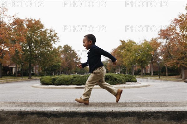 African American boy playing on suburban street