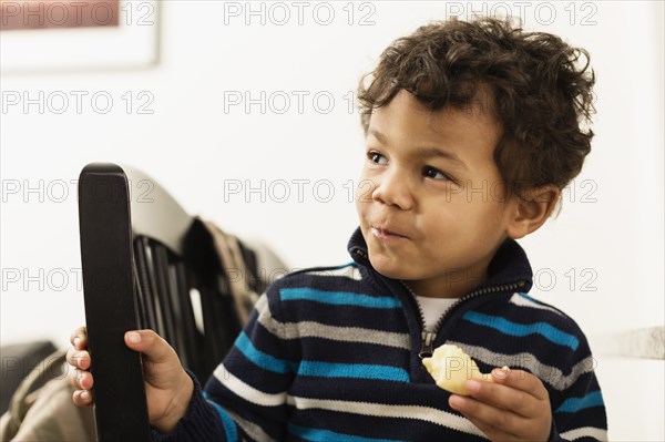 Mixed race boy eating at counter