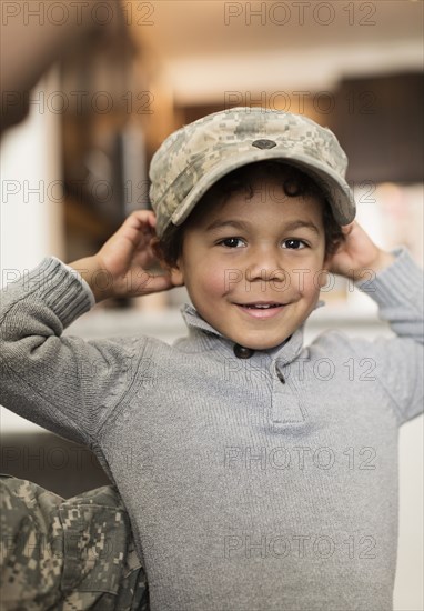 Mixed race boy wearing soldier cap