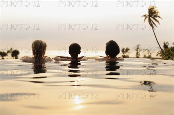 Women admiring scenic view in infinity pool