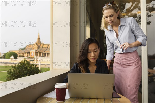 Businesswomen working on laptop in cafe