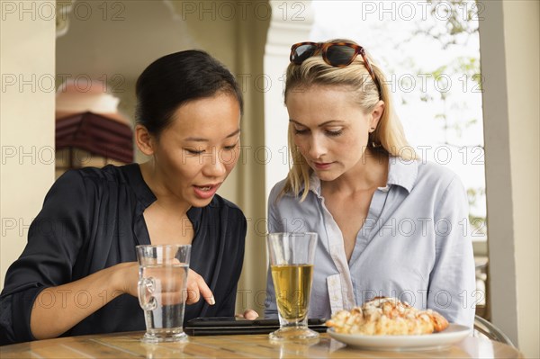 Businesswomen using digital tablet in cafe