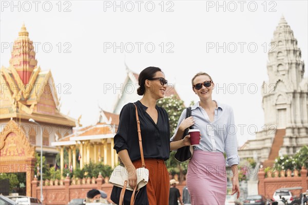 Businesswomen walking by ornate temple