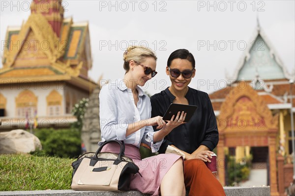 Businesswomen using digital tablet near temple