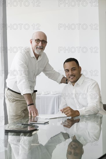 Hispanic businessmen smiling in office meeting