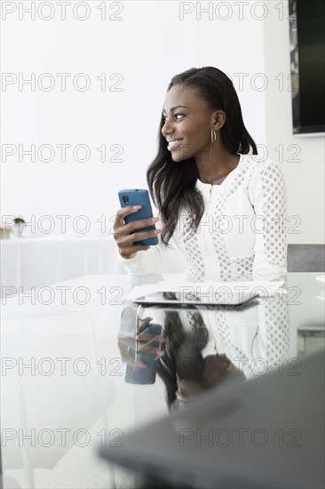 Businesswoman using cell phone in conference room