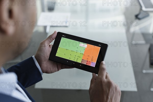 Hispanic businessman viewing graph on digital tablet