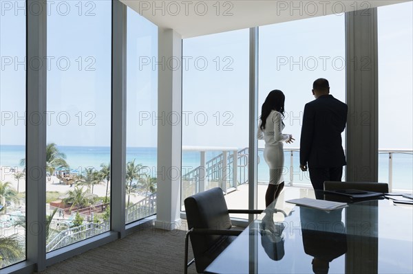 Business people looking out conference room window