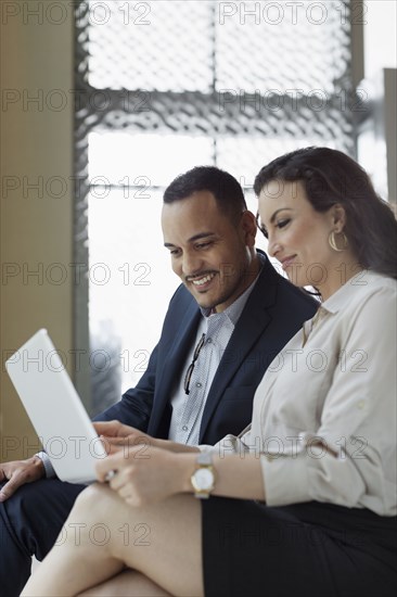 Business people using laptop in hotel lobby