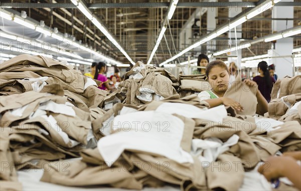 Workers folding clothing in garment factory