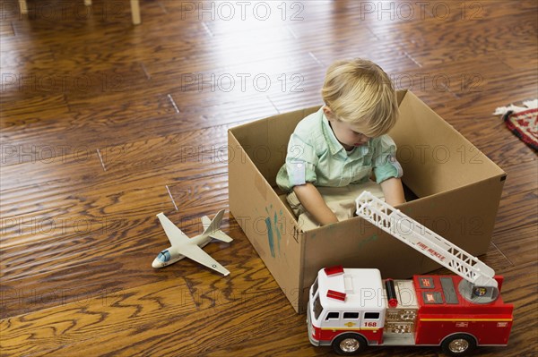 Caucasian boy playing in cardboard box