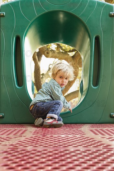Caucasian boy climbing on play structure in playground