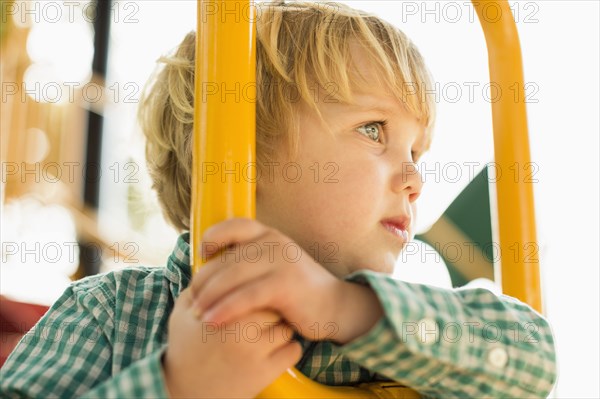 Caucasian boy on play structure in playground