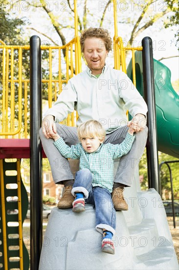 Caucasian father and son playing on play structure