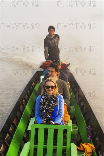 Tourists riding in canoe on rural lake