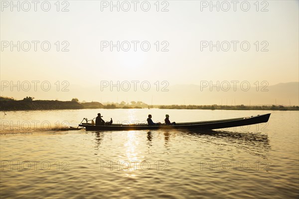 Tourists riding in canoe on rural lake