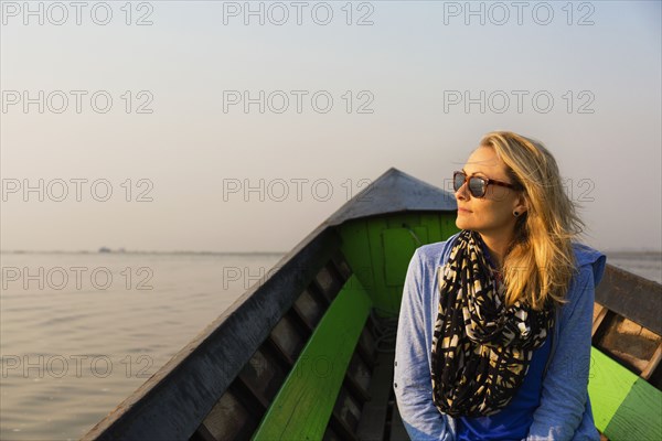 Caucasian woman riding in canoe on rural lake