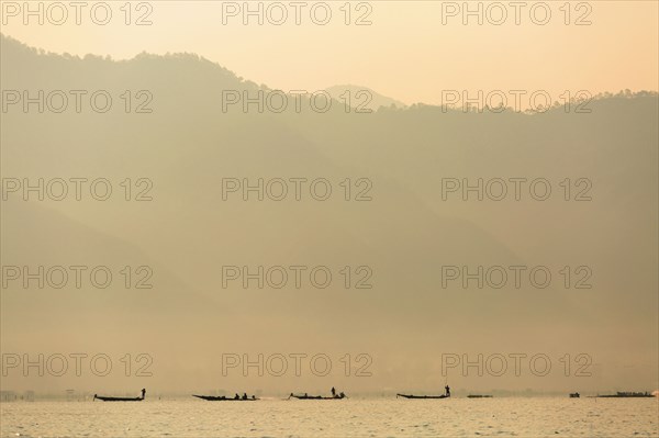 Silhouette of canoes floating on rural lake