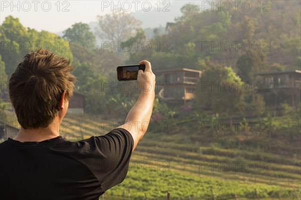 Caucasian man photographing rural fields