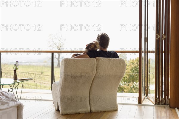 Caucasian couple lounging on balcony