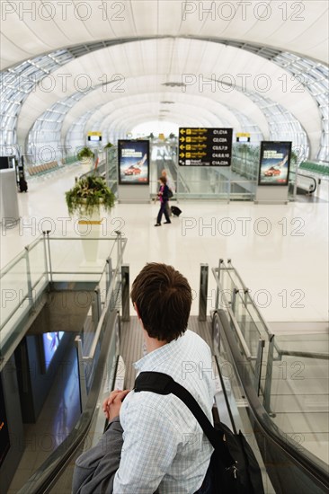 Caucasian businessman on escalator in airport