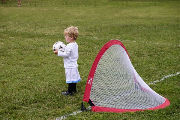 Caucasian boy playing soccer in field