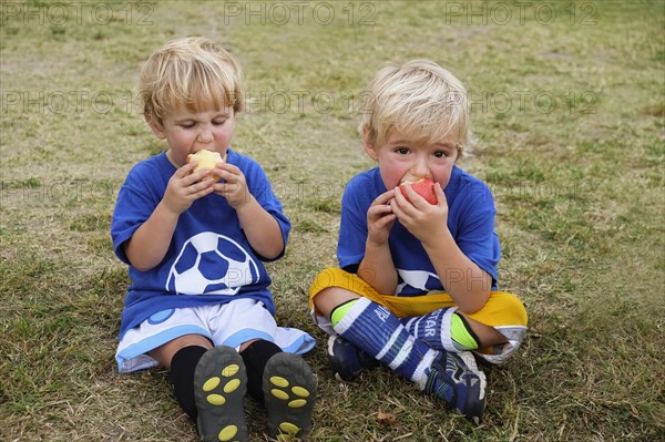 Caucasian soccer players eating apples