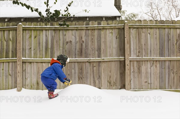 Caucasian boy playing in snow