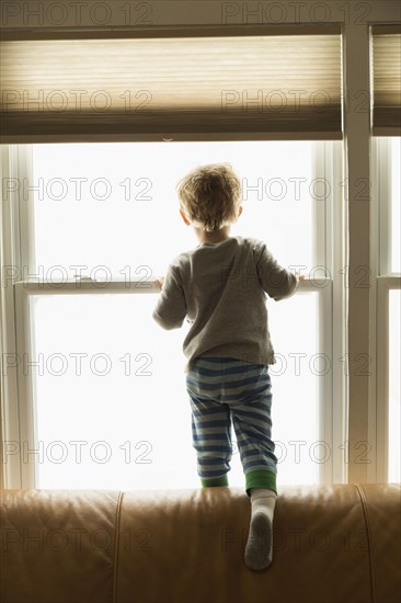 Caucasian boy looking out window