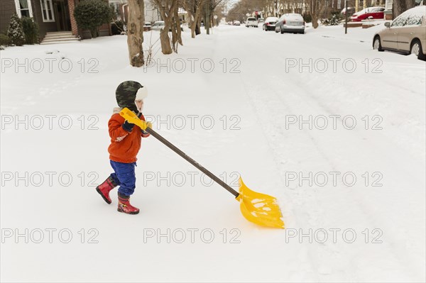 Caucasian boy shoveling snow